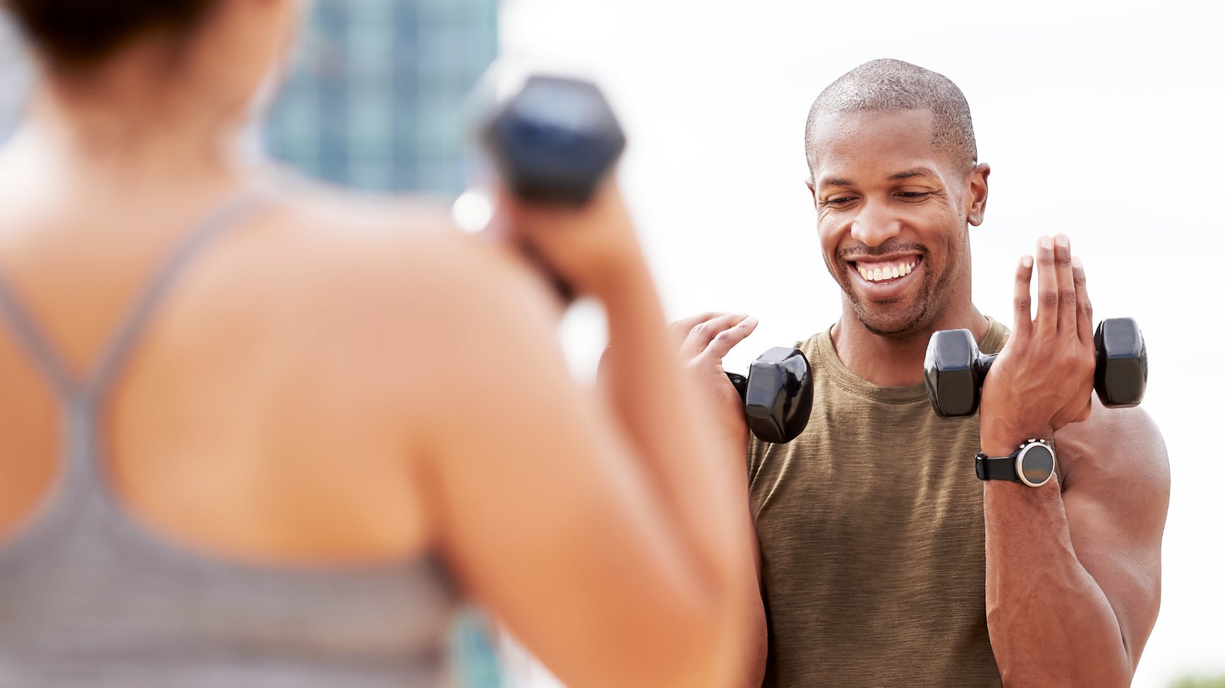 a man and a woman doing curls with weights