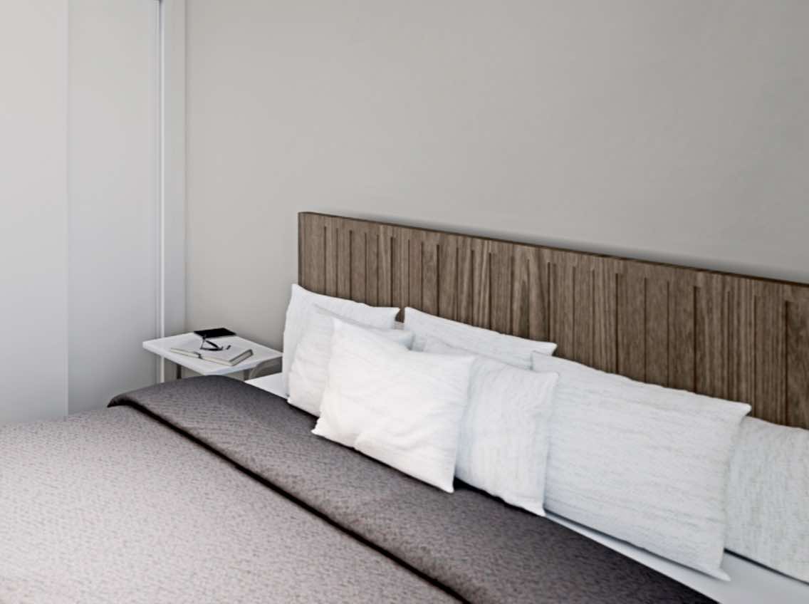 A large king-sized bed with a natural wood headboard and fresh white pillows