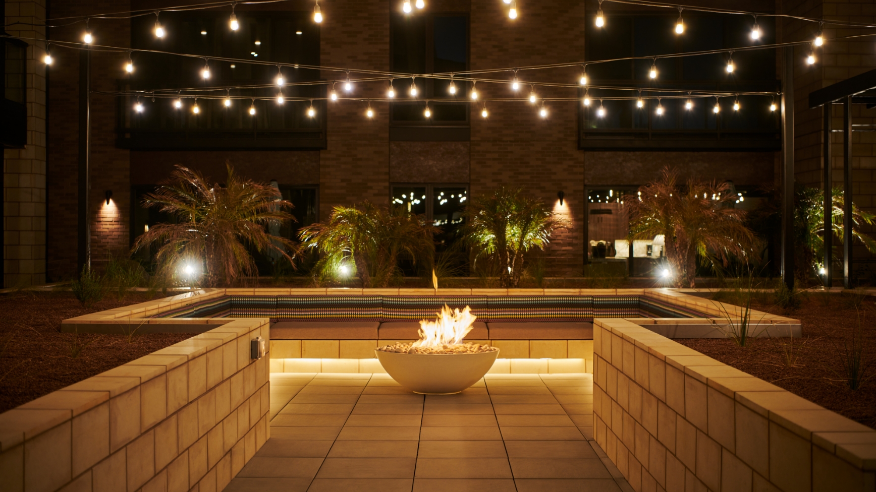 a fire pit and seating area in a community space at the Life Time Living location